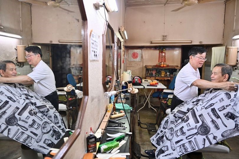 “这次换我来请多多指教” 曹观友为理发师剪发