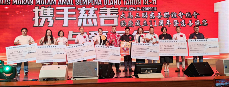 大马三联慈善联谊会捐出总数2万3000令吉给予1家慈善机构和6所华小,各机构代表上台接领模拟支票,左六起为陈昭日和蔡国豪。