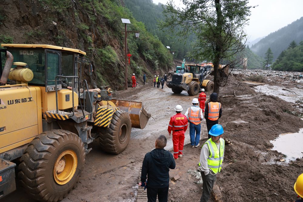 救援人员在榆中县马坡乡山洪灾害现场抢修中断道路