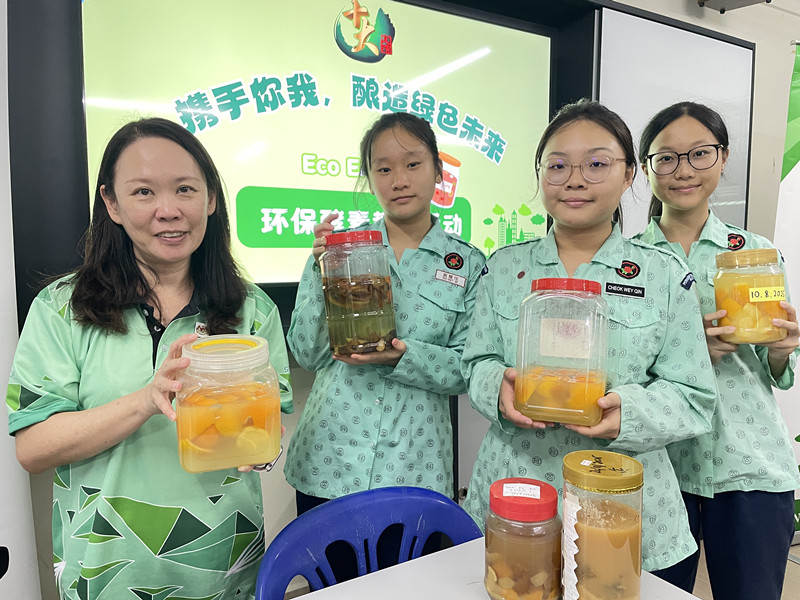 邓伊菁老师(左)与学生合力制作环保酵素,预计数月后即可“开箱”使用。