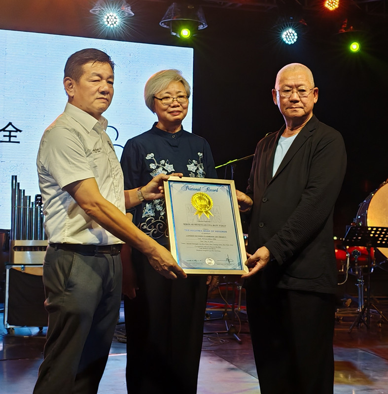 郭进鸿（左）移交《马来西亚纪录大全》证书予苏文忠（右），由颜碧贞（中）见证。