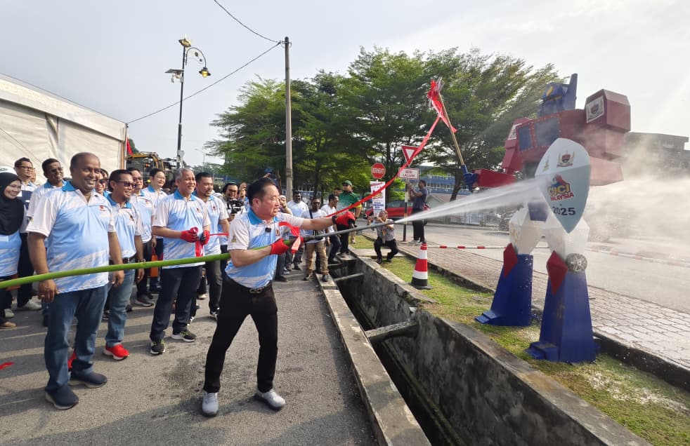 黄瑞林(中)用水炮为巴生皇城市政厅“清洁大马日”主持仪式。