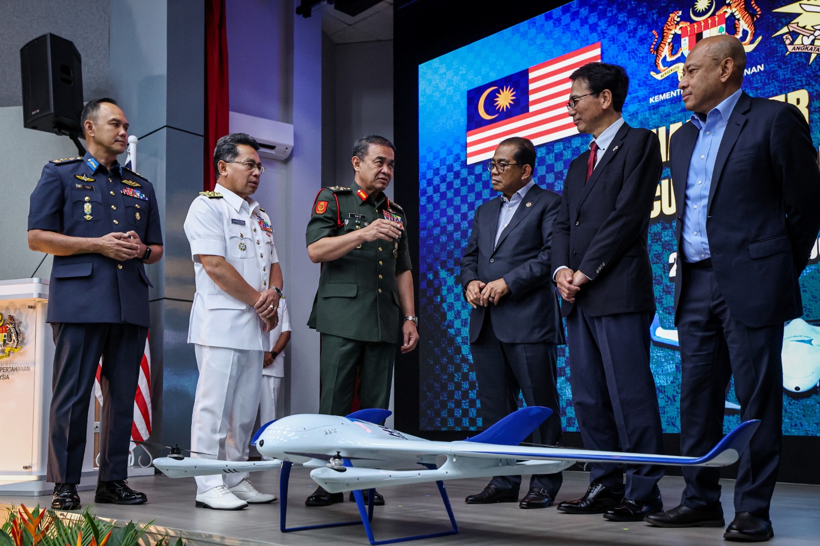 卡立诺丁（右三起）聆听大马陆军首长丹斯里莫哈末哈菲祖德丁讲解装备详情，右二为四方敬之。