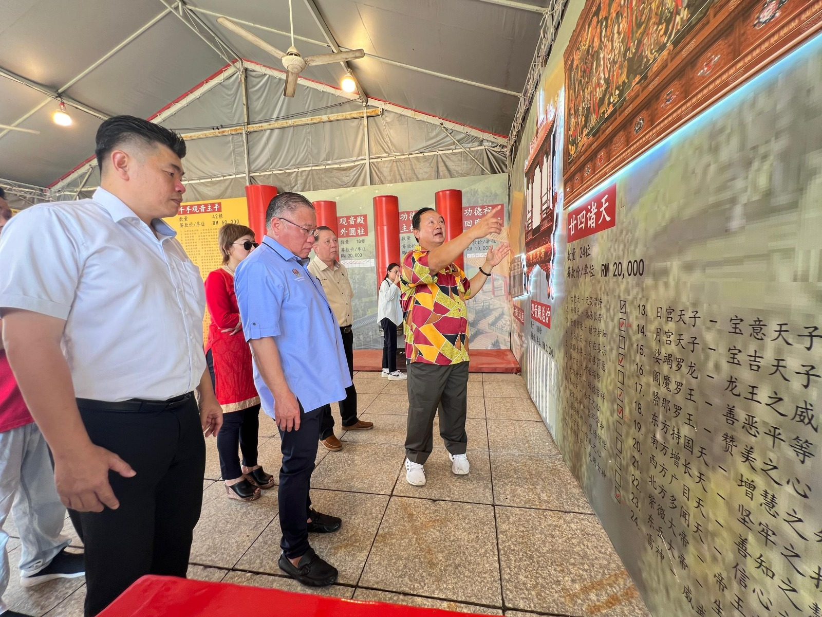 马金福（右）向张庆信讲解正在筹募兴建的“廿四诸天”，左为朱建华。