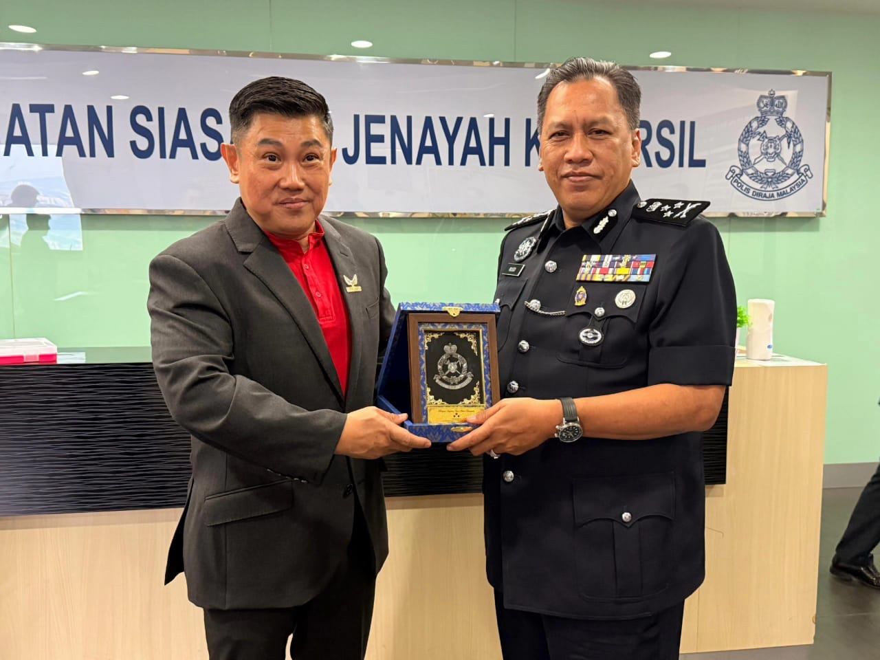 李治荣(左) 领取由武吉阿曼商业罪案调查局代表颁发纪念状。