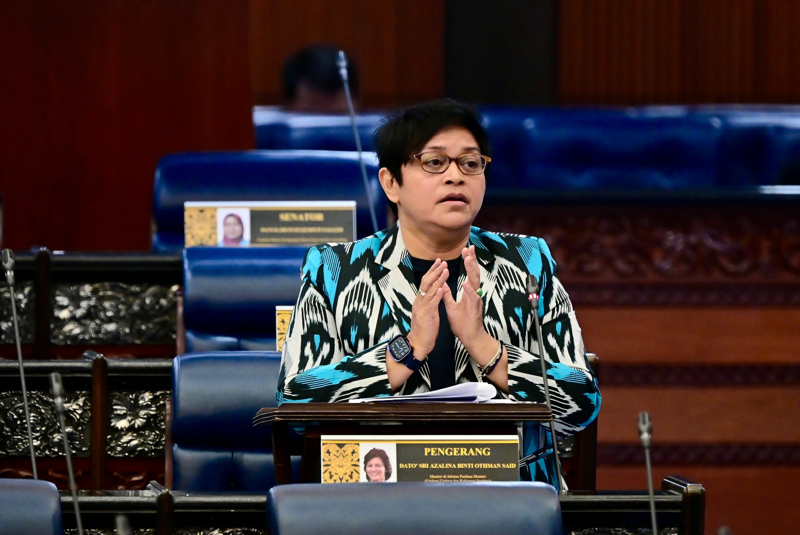 阿莎丽娜身穿一件鲜绿色图案的西装外套。