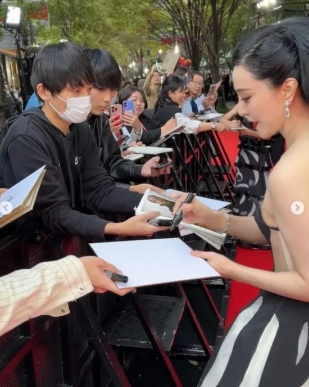 范冰冰在红毯上为疯狂的影迷签名甚至合照，走了超过半小时。