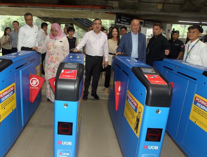 麦慕娜(前排左起)、陆兆福及黄一宗,与一众嘉宾乘搭轻快铁抵达“市中心- 大华银行”站。